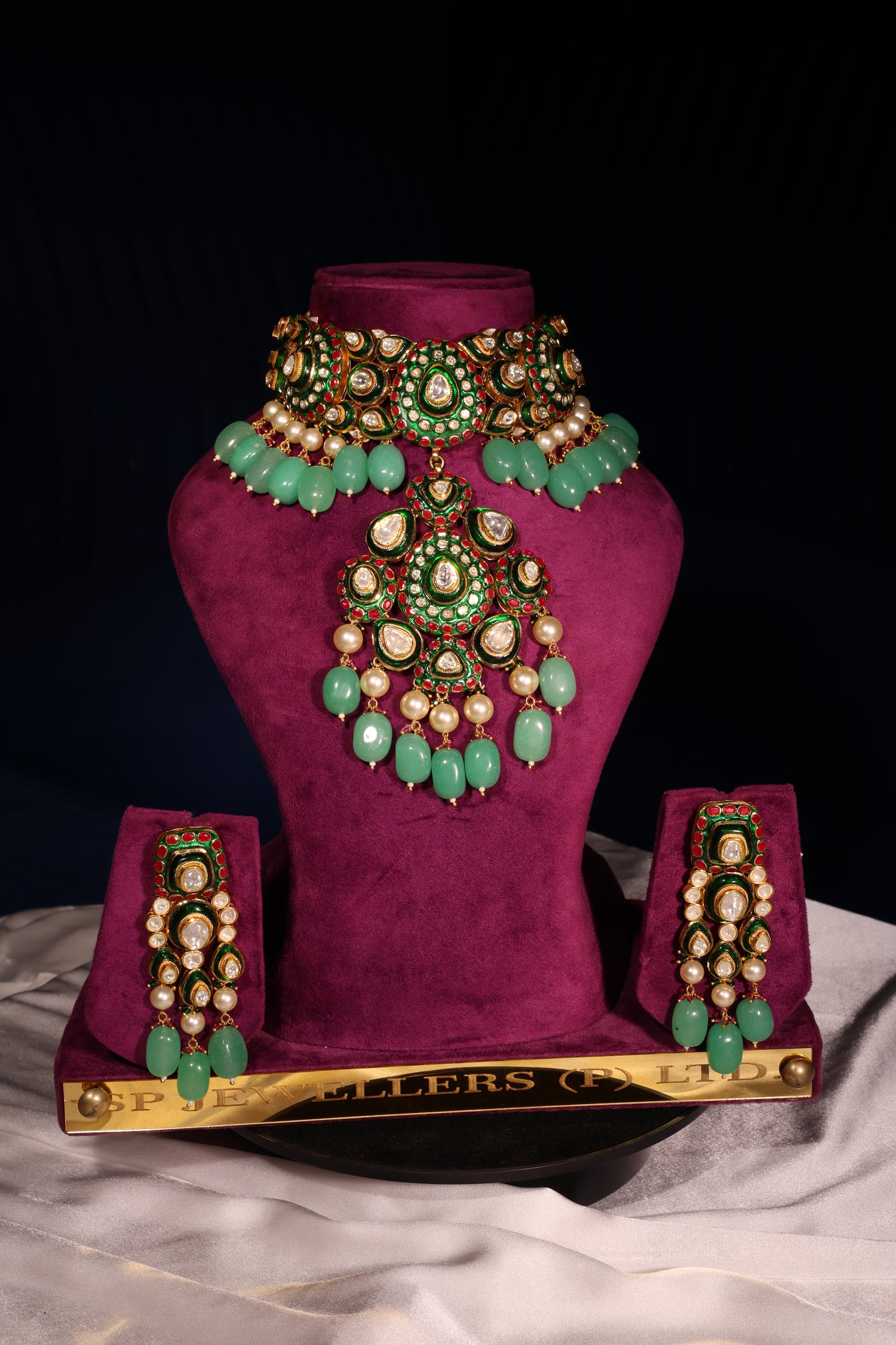 Decorative purple garment with green and gold embellishments on a black background