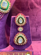 Decorative Polki earrings on a purple stand with a blurred background "SP. Jewellery"