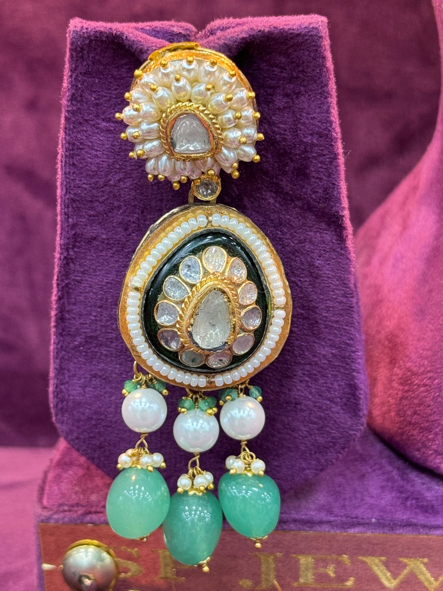 Polki earrings earrings with green and gold elements on a purple cushion "SP. Jewellers"