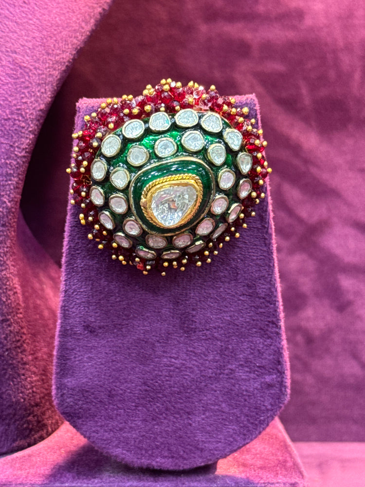 Polki earrings with gemstones on a purple stand against a pinkish-purple background "SP. Jewellers"