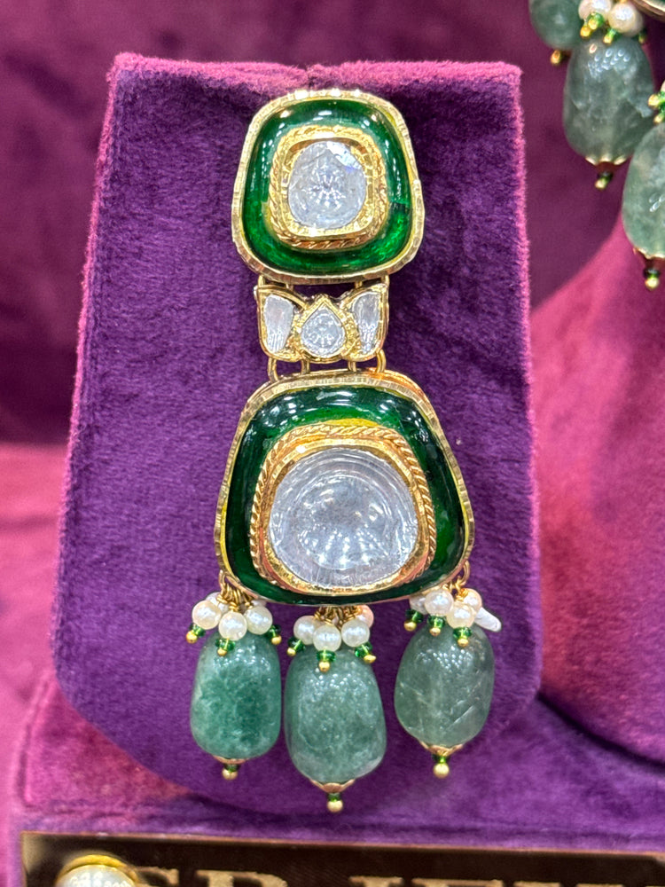 Green and gold Polki earrings on a purple stand "SP. Jewellers"